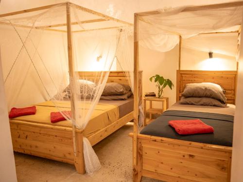 a bedroom with two bunk beds with mosquito nets at Old Stone Boutique Lodge in Bagamoyo