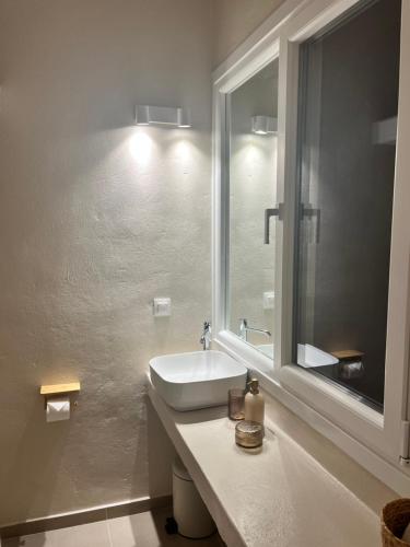 a bathroom with a sink and a window at Aelia in Vári
