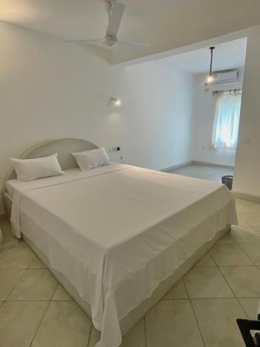 a large white bed in a white room at Bliss home in Watamu