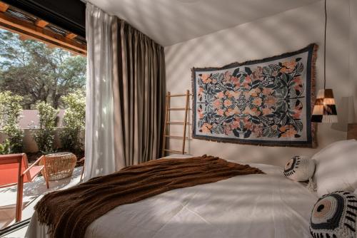 a bedroom with a bed and a tapestry on the wall at NINEMO Village in Fternón