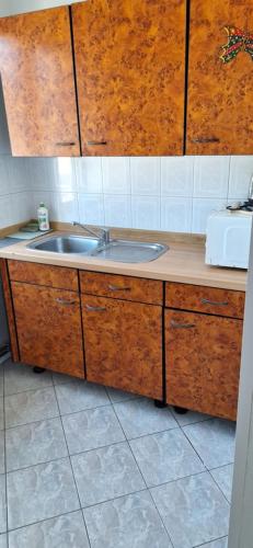 a kitchen with a sink and wooden cabinets at Dziwnów 2 in Dziwnów