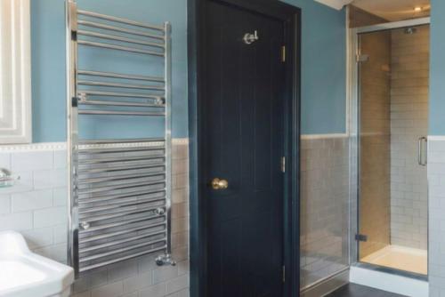 a bathroom with a shower and a black door at The Crown & Thistle, Abingdon, Oxfordshire - Acorn Pubs in Abingdon