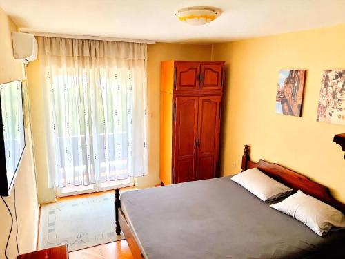 a bedroom with a bed and a large window at Kiwi house in Podgorica