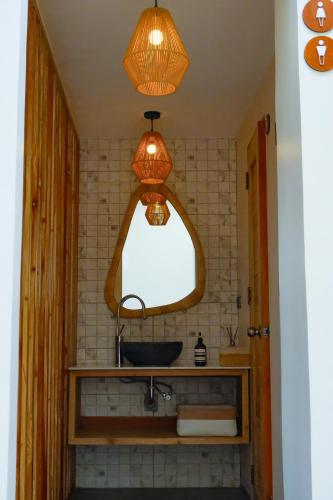 a bathroom with a sink and two lights above it at Soluna Siquijor Boutique Resort in San Juan