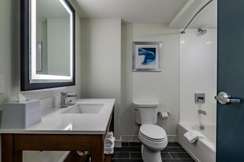 a bathroom with a sink and a toilet and a mirror at Four Points by Sheraton Brunswick in Brunswick