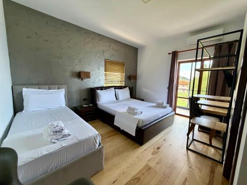 a hotel room with two beds and a window at Hotel Victoria in Pogradec