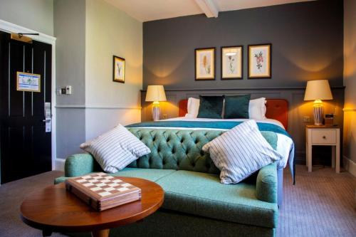 a bedroom with a blue couch and a bed at The Crown & Thistle, Abingdon, Oxfordshire - Acorn Pubs in Abingdon