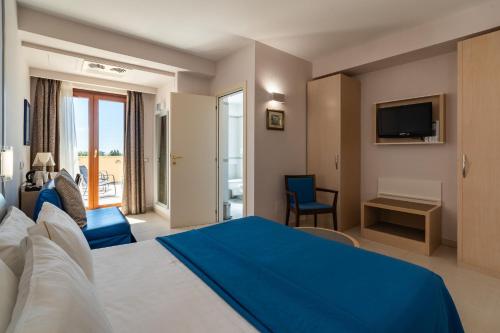 a hotel room with a bed and a tv at Kora Park Resort in Formia