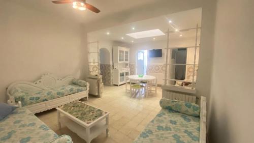 a living room with two beds and a table at Nice house ideally located in Dar Tahar Zaouch