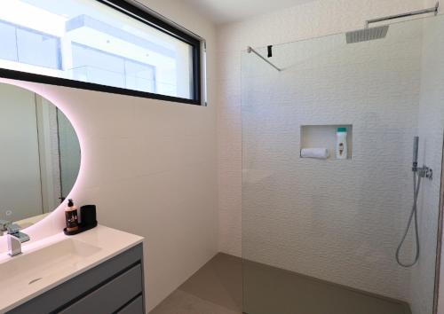 a bathroom with a shower with a sink and a mirror at Villa Pingau in Vila Nova de Gaia
