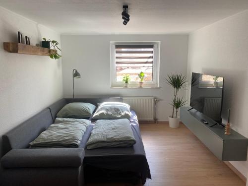 a bed in a room with a couch and a window at Ferienwohnung Sollingseck in Dassel