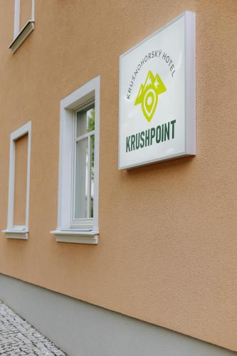 a sign on the side of a building at KRUSHPOINT Krušnohorský hotel in Horní Blatná