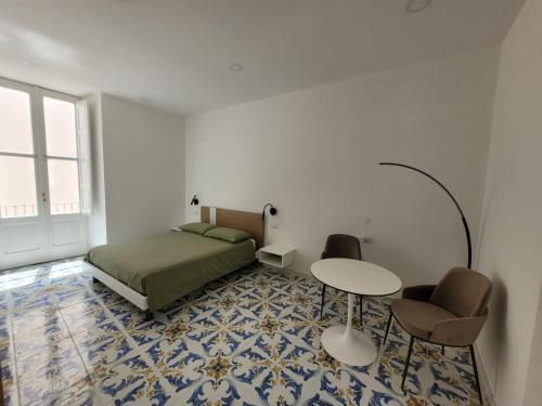 a bedroom with a bed and a table and chairs at Le Terrazze in Tropea