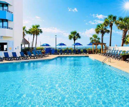 a pool with chairs and umbrellas at a resort at New ! Ocean Reef Resort-Unique Renovated Oceanfront Condo -Free parking - Amazing pools & Views in Myrtle Beach
