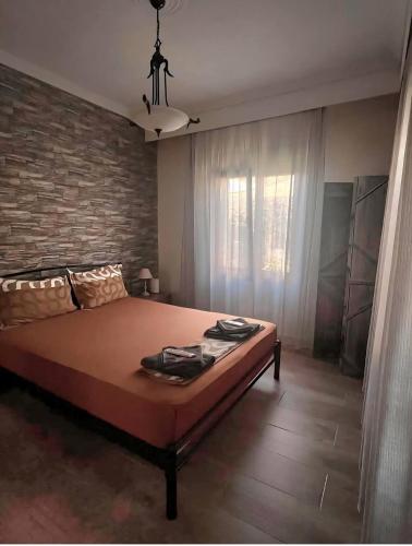 a bedroom with a large bed and a brick wall at John and Tania's Garden in Prinos