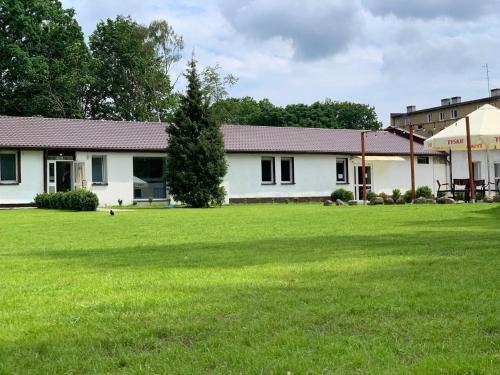 a house with a large green lawn in front of it at Galeria PRL in Borne Sulinowo