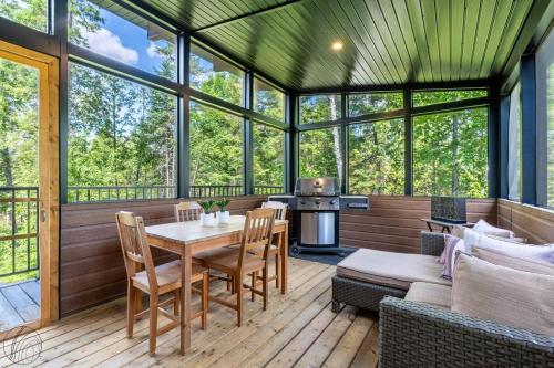 a screened in porch with a table and chairs at Le Clorane spa relax in Chertsey