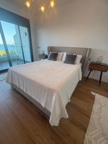 a bedroom with a large bed with a large window at New front line beach-golf La Alcaidesa San Roque The Links 1 in San Roque