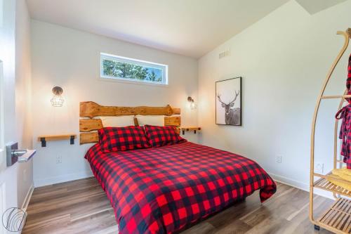 a bedroom with a red and black plaid bed at Le Clorane spa relax in Chertsey
