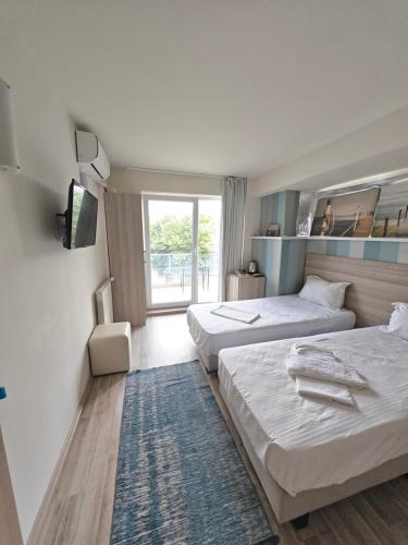 a hotel room with two beds and a television at Anna ByTheSea By iVAVev in Eforie Sud