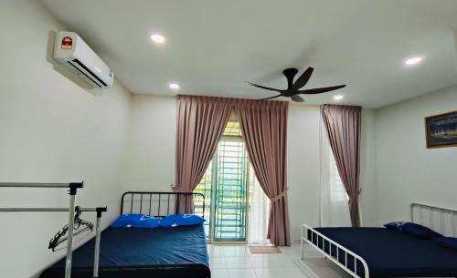 a bedroom with two beds and a ceiling fan at 25 Homestay Pulai in Johor Bahru