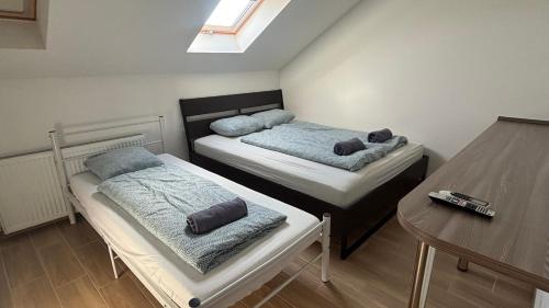 two beds in a small room with a table at Budapest Airport Smart panzio in Vecsés
