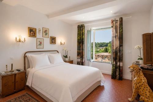 a bedroom with a white bed and a window at Maison Aimé in La Motte