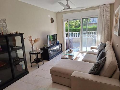 a living room with a couch and a television at Apartment Miami Platja 80 m² Pool in Miami Platja