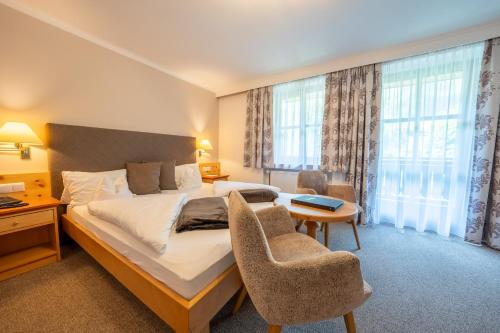 a hotel room with a bed and a table and chairs at Hotel Krimmlerfälle in Krimml