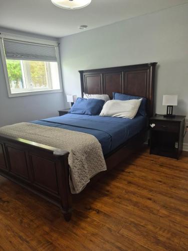 a bedroom with a bed with blue sheets and a window at Comfortable stay - 2-bedroom apartment in Saint John