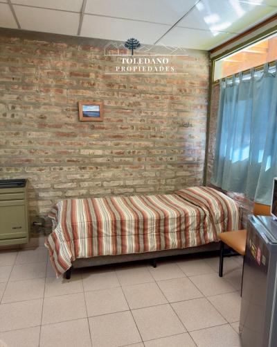 a hospital room with a bed against a brick wall at Costa Azul 3 in Villa Pehuenia