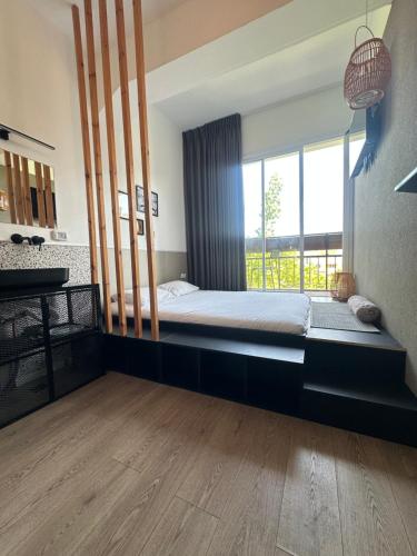 a bedroom with a bed and a large window at L7 Urban Studios in Tel Aviv
