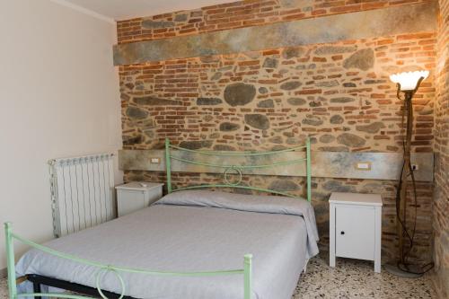 1 dormitorio con cama y pared de ladrillo en Affittacamere da Beppe, en Altopascio