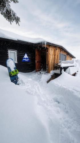 a snowboard in the snow in front of a building at Cordillera Hostel in Farellones
