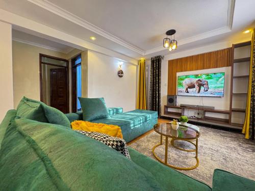 a living room with a green couch and a table at Riverview greenstar cozy homes in Kisii
