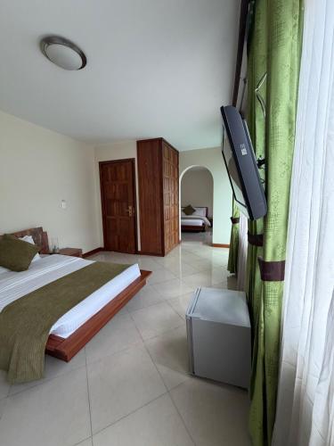 a bedroom with a bed and a flat screen tv at Apartahotel Vincent Suites in Pasto