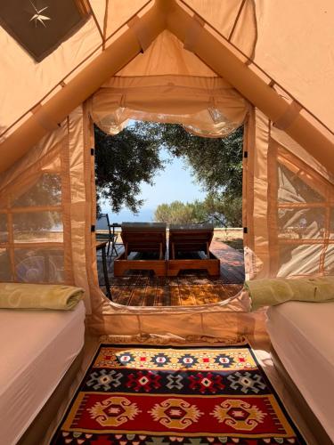 a room with a view of a tent with a rug at Cimarte The Path Lukove in Lukovë