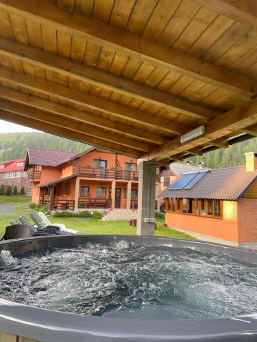 a hot tub on a patio with a house at Casa Mona in Arieşeni