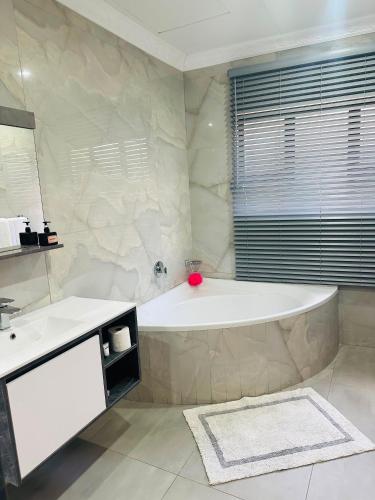 a white bathroom with a tub and a sink at Sharks View in Port Shepstone