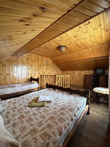a bedroom with a large bed with a wooden ceiling at Hotel Dudarik in Kosiv