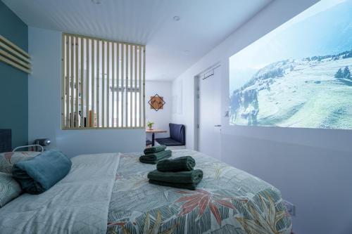 a bedroom with a large bed with green pillows on it at Studio cosy Allevard in Allevard