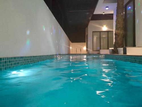 a swimming pool with blue water in a hotel at Alpha Holiday Home in Barka