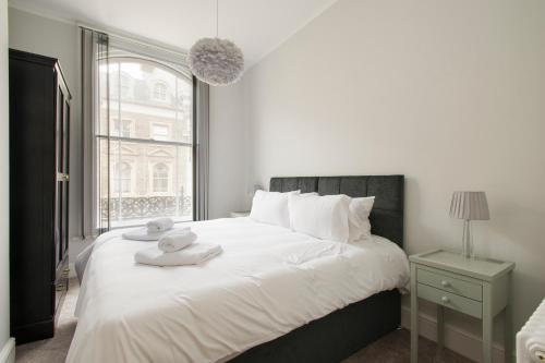 a bedroom with a large white bed with a window at Market Street Apartments - City Centre Modern 1bedroom Apartments with NEW WIFI and Very Close to Tram in Nottingham