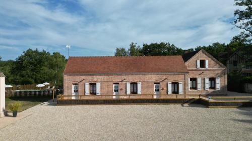 an old brick house with a roof on a driveway at Les Nuitées de Bois Renaud Chambre d'Hôtes LA FORET in Marcilly-en-Gault