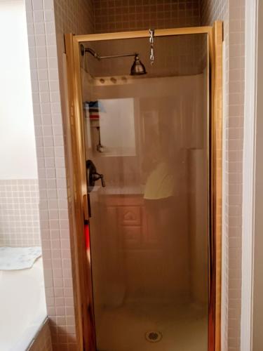 a shower with a glass door in a bathroom at WELCOME TO My COTTAGE in Sunland