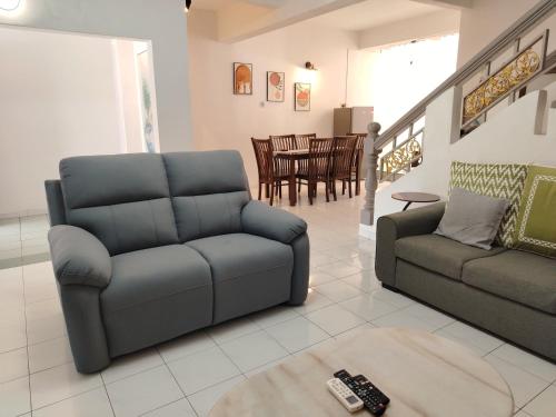 a living room with a couch and a chair at SS Ipoh Comfort Homestay - Taman Bertuah in Ipoh