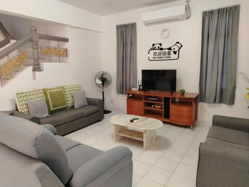 a living room with a couch and a tv at SS Ipoh Comfort Homestay - Taman Bertuah in Ipoh