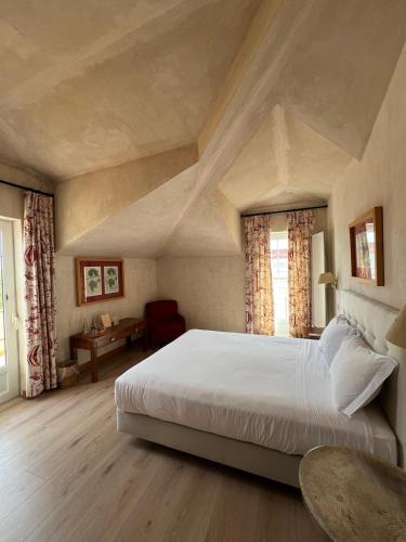 a bedroom with a large bed in an attic at Quinta De Catralvos in Azeitao