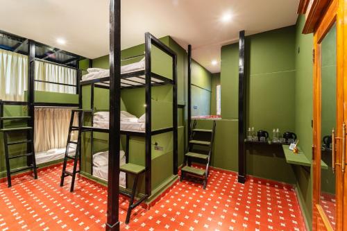 a room with four bunk beds and a desk at Versailles Backpacker Hostel in Pondicherry