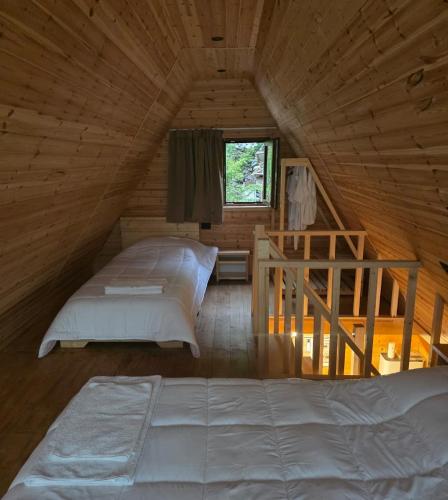 a bedroom with two beds in a wooden cabin at Mrizi i Drinit in Arrëz